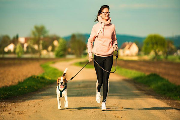 Young lady enjoying a walk with her dog.